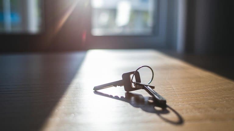 A small ring of keys resting on a wooden table in morning light